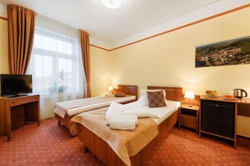 a hotel room with two beds and a television at Hotel Tábor in Tábor