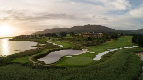 an aerial view of a golf course with a lake at Arabella Hotel, Golf and Spa in Kleinmond