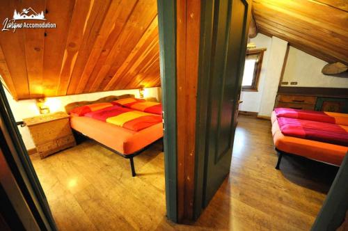 een slaapkamer met een bed en een bank in een kamer bij Al Mé Bait vicino alla Latteria e allAquagranda in Livigno