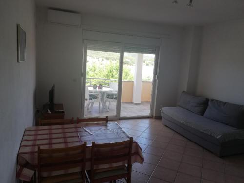 un soggiorno con tavolo e divano di Apartments Marijan - sea view a Veli Rat