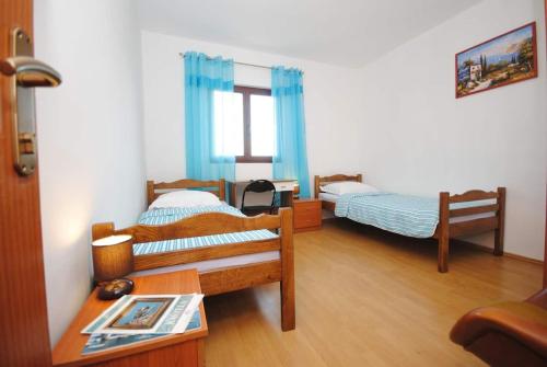 a room with two beds and a table with a table sidx sidx sidx at Apartments Ezgety - 330m from beach in Kaštela
