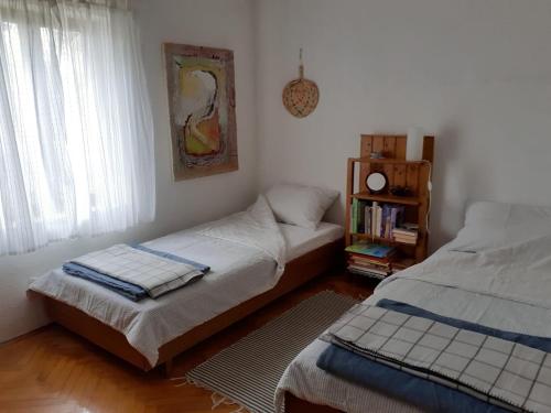 1 dormitorio con 2 camas y estante para libros en Holiday home Olive- 150m from sea, en Splitska