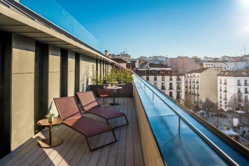 a balcony with chairs and a view of a city at Ocean Drive Madrid in Madrid