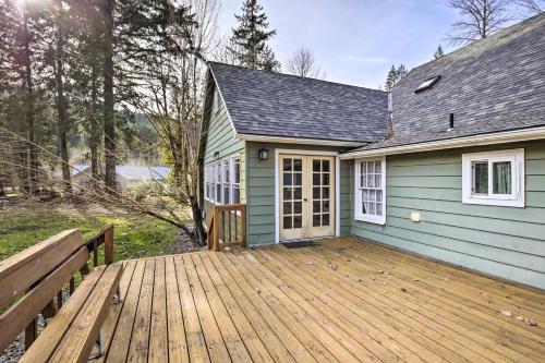 a house with a wooden deck in front of it at Remote Escape Riverside Home with Scenic Views in Idanha