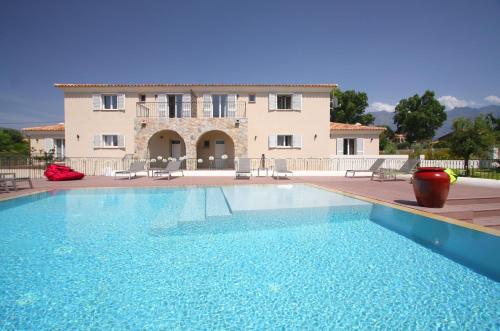 une grande piscine en face d'une maison dans l'établissement Residence Catherine, à Calvi