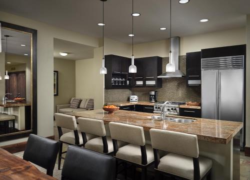 a kitchen with a large island with chairs around it at One Village Place by Vacation Club Rentals in Truckee