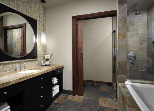 a bathroom with a sink and a tub and a mirror at One Village Place by Vacation Club Rentals in Truckee