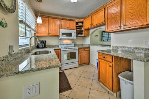 a kitchen with wooden cabinets and white appliances at Apollo Beach Gem with Pool The Flamingo House in Apollo Beach