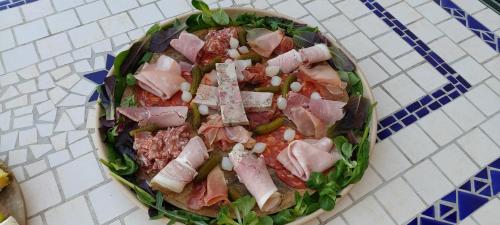 a plate of food with meat and vegetables on a table at Chambre d'hôtes des Loyes in Jaillans
