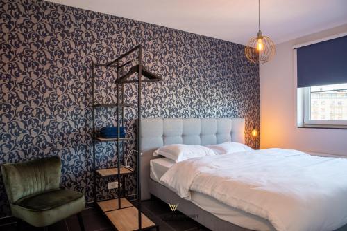 1 dormitorio con 1 cama y 1 silla en New modern apartment near the sea and city centre, en Ostende