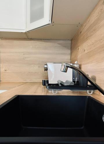 - un comptoir de cuisine avec un évier et un canapé dans l'établissement CHEZ FIFI - studio 28m2 - hyper centre - wifi, à Cassis