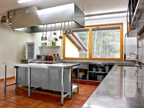 a kitchen with a stainless steel island in the middle at Holiday Home Runnimoos-1 by Interhome in Innerlaterns