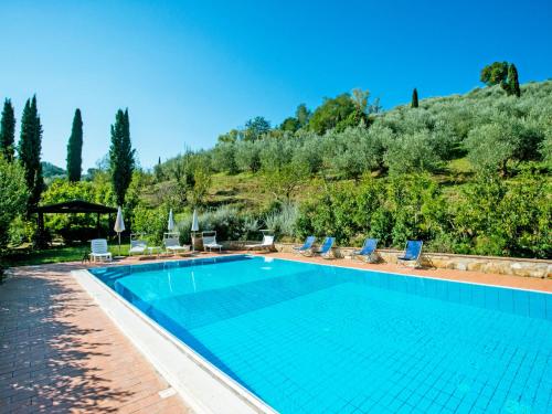uma piscina com cadeiras e uma montanha ao fundo em Holiday Home Il Masso-4 by Interhome em La Collina