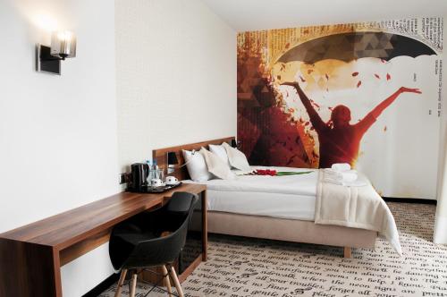 una habitación de hotel con una cama con una pintura en la pared en Hotel Piano, en Lublin