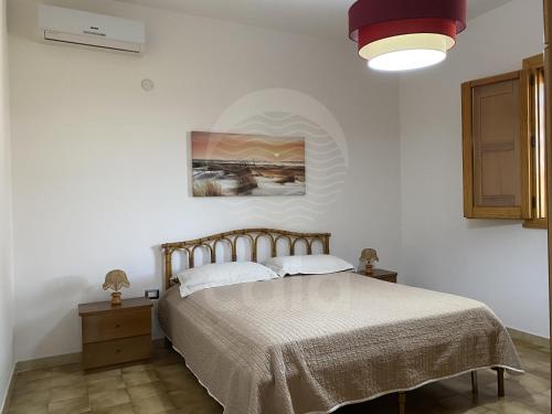 トッレ・ラピッロにあるVilla Sunshineのベッドルーム1室(ベッド1台付)が備わります。壁には絵画が飾られています。