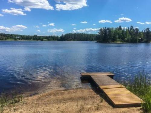 a lake with a wooden dock in the water at Holiday Home Riihiranta by Interhome in Petäjävesi