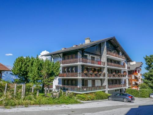 a large building with a car parked in front of it at Apartment Mont-Soleil-2 by Interhome in Nendaz