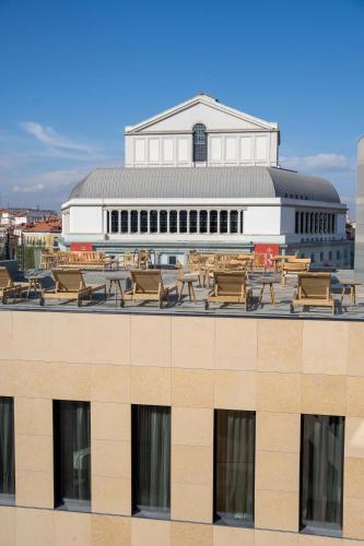 a view of the roof of a building with tables and benches at Ocean Drive Madrid in Madrid