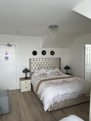 a white bedroom with a large bed and two lamps at Jasmine House in Newquay