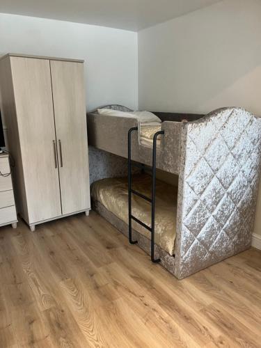 a room with two bunk beds and a cabinet at Jasmine House in Newquay