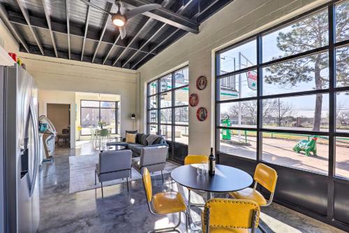 a living room with a table and chairs and windows at Unique Texas Home in Converted Gas Station! in Schulenburg