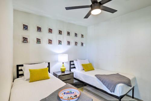 two beds in a room with a ceiling fan at Unique Texas Home in Converted Gas Station! in Schulenburg