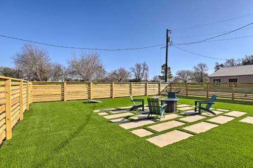 a fence with chairs and a table in the grass at Unique Texas Home in Converted Gas Station! in Schulenburg