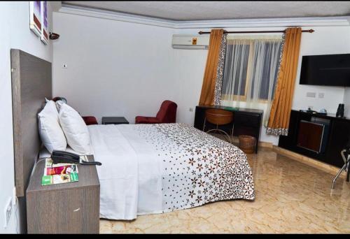 una camera d'albergo con letto e TV di ROYAL BASIN RESORT a Kumasi