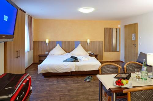 a hotel room with a bed and a tv at Waldhotel Felschbachhof in Ulmet
