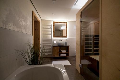 a bathroom with a tub and a sink and a mirror at Konradgut 11 - Ruhe und Aussicht auf 1140m in Sankt Lorenzen ob Murau