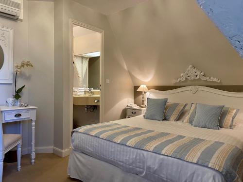 a bedroom with a bed and a sink and a mirror at Château Hôtel Edward 1er in Monpazier