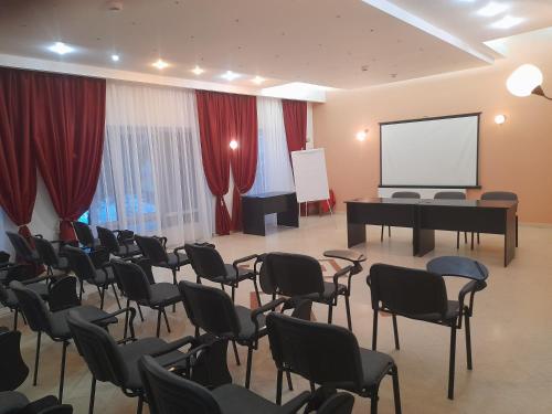 a room with a piano and chairs and a screen at Hotel Miraj - Restaurant & Sauna & Biliard in Poiana Brasov