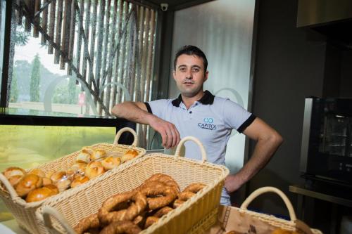a man standing next to two baskets of bread at Accra Luxury Apartments @ Pearl in Accra