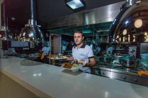 a man standing in a kitchen with a plate of food at Accra Luxury Apartments @ Pearl in Accra