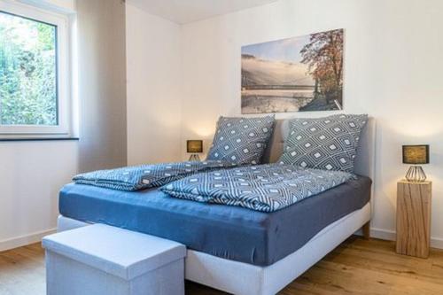 a bedroom with a blue bed with a painting on the wall at Weinrebe in Bernkastel-Kues