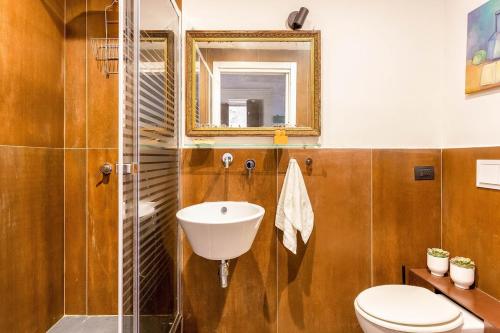 un bagno con lavandino, WC e specchio di Sicilianinsta Rooms a Catania