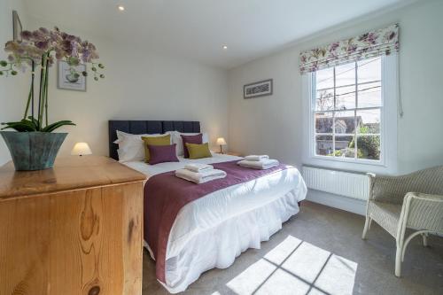 um quarto com uma cama grande e uma janela em Adorable cottage with a log burner in heavenly village - Constable Lodge em Nayland