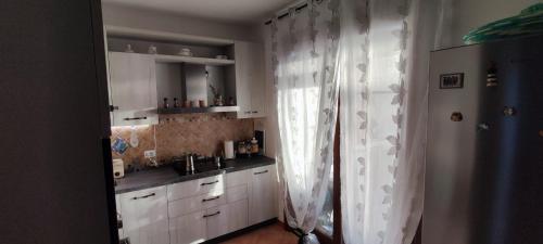 a kitchen with white cabinets and a sink and a window at Casa Antares in Stintino