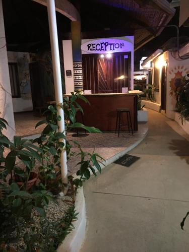 a sign for a reception in a building at Pura Vida Hostel in Tamarindo
