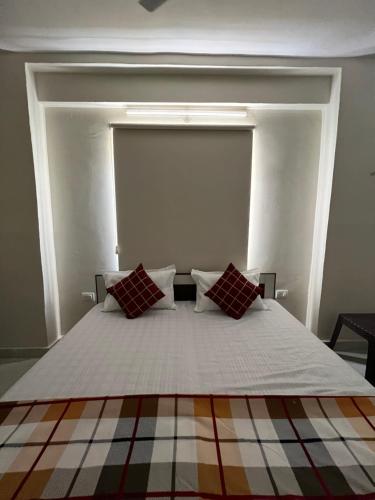 a bedroom with a bed with two red pillows at Hostel ivory in Jaipur