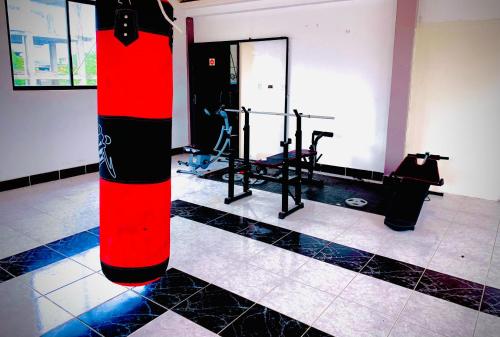 a gym with a red and black pole in a room at Hotel Oro Blanco in Atacames