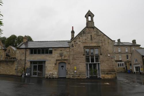 an old brick building on a wet street at Apartment 4 Tomlinsons Apartments in Rothbury