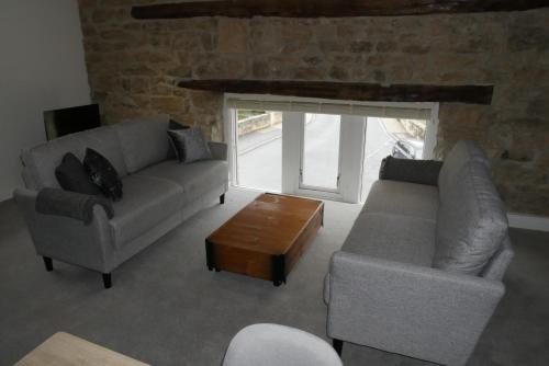 a living room with two couches and a coffee table at Apartment 4 Tomlinsons Apartments in Rothbury