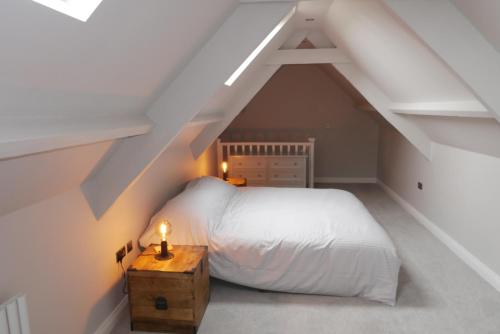 una camera da letto con letto bianco in mansarda di Apartment 4 Tomlinsons Apartments a Rothbury
