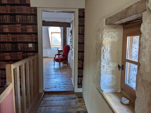 a hallway with a room filled with bookshelves at La Licorne - Renovated Townhouse in St Gengoux in Saint-Gengoux-le-National
