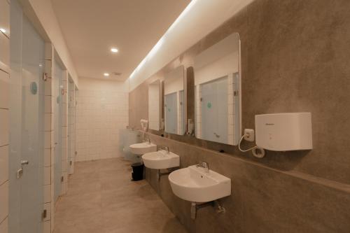a bathroom with two sinks and two mirrors at Bobopod Alun-Alun, Malang in Malang