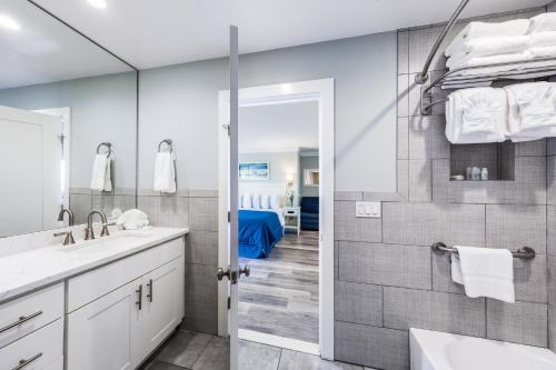 a bathroom with a tub and a sink and a shower at Hartman's Briney Breezes Beach Resort in Montauk