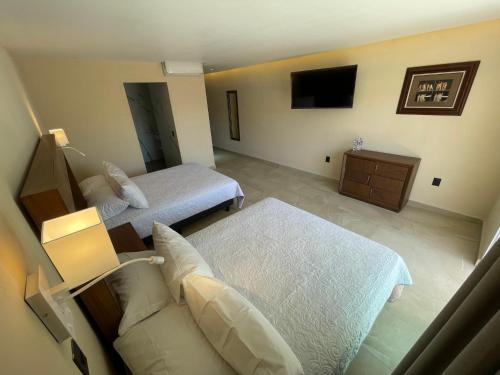 a bedroom with two beds and a couch and a television at Hotel Balcón del Cielo in Guanajuato