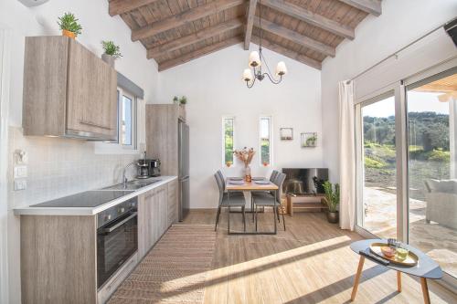 a kitchen with wooden cabinets and a dining room with a table at Ktima Arillas in Arillas