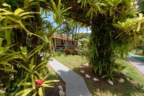 a garden with green plants and a house in the background at Minha Glória Hotel Boutique in Bom Jardim
